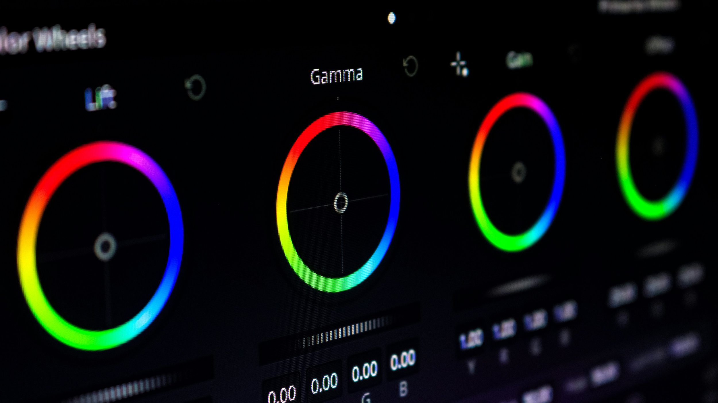 Roues de réglage des couleurs sur un écran d'édition vidéo, avec des cercles colorés indiquant les paramètres de gamma, lift et gain.